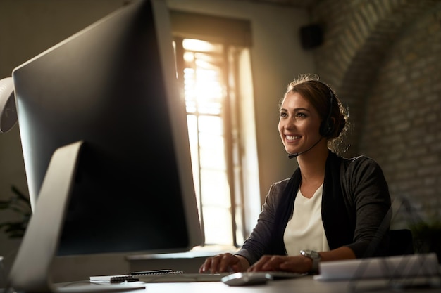 Free photo happy businesswoman typing an email on desktop pc in the office